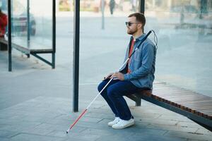 cegado hombre esperando para autobús a un autobús estación foto