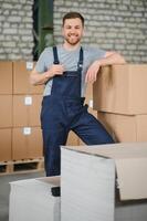 Warehouse worker carrying a carton for delivery to production stock. photo