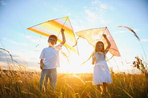 Children running with kite in the field. photo