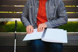 Blinded man reading by touching braille book photo