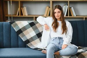 chica feliz con ropa informal sentada en el sofá foto