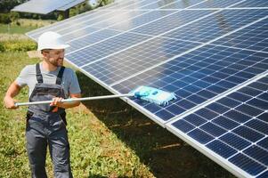 young worker cleaning solar panels. photo