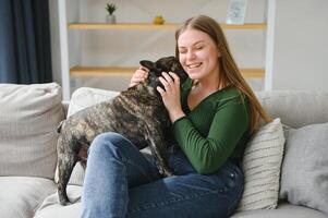 Female owner playing with joyful dog at home. Playing with dog concept photo