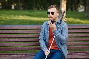 joven cegado hombre utilizando teléfono y enviando voz mensaje foto