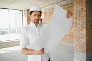 Close up engineers working on a building site holding a blueprints.Engineering and architecture concept photo