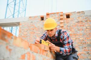 trabajador de la construcción en uniforme y equipo de seguridad tiene trabajo en la construcción foto