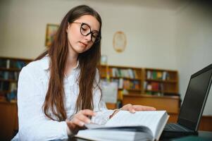 Portrait of a student girl studying at library photo