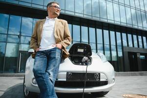 un empresario cargos un eléctrico coche foto