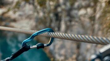 carabiner with climbing rope on rocky background. Climbing concept photo