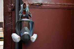 The respirator hangs on the door of the entrance to the bomb shelter. photo