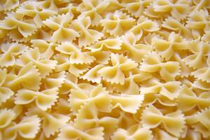 A lot of pasta in the shape of a butterfly on the table as a background. photo