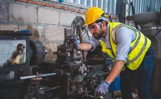 Portrait of Heavy industry workers working on the metal fabrication process by operating a lathe at a machine for steel structure industry. photo