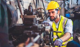 Portrait of Heavy industry workers working on the metal fabrication process by operating a lathe at a machine for steel structure industry. photo