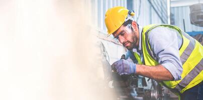 Portrait of Heavy industry workers working on the metal fabrication process by operating a lathe at a machine for steel structure industry. Panorama image use for cover design. Selective focus photo