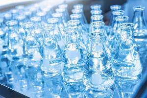 Glass flask with liquid in laboratory. Blue tone. Selective focus. photo