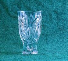 Empty crystal vase on green background. The vase was made in the mid-20th century. photo