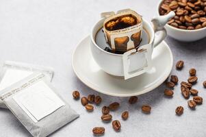 Drip coffee bag with ground coffee in  cup photo