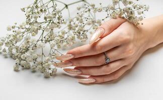 Hand of a young woman with white pearl  manicure photo