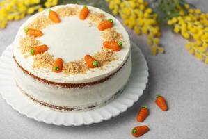 Homemade carrot cake made with walnuts, iced with cream cheese. Sweet dessert. photo