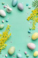 Festive Easter Decoration With Colorful Eggs and Mimosa Flowers on a Pastel Green Background photo