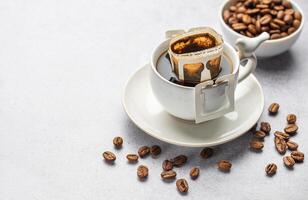 Drip coffee bag with ground coffee in  cup photo