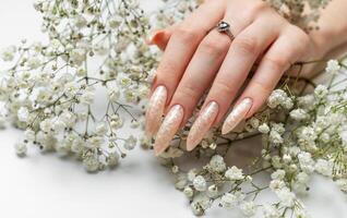 Hand of a young woman with white pearl  manicure photo