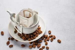 Drip coffee bag with ground coffee in  cup photo