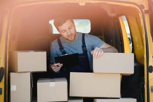 The courier brought the delivery of the box to the client. Courier service employee in uniform. photo