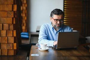 man using laptop in cafe bar photo