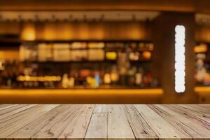 image of wooden table in front of abstract blurred background of coffee shop lights.Blur coffee shop or cafe restaurant with abstract bokeh light background. photo