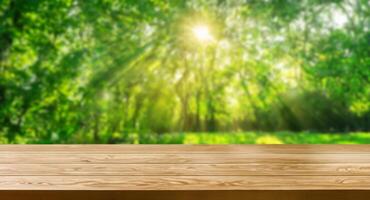 Brown wood table in green blur nature background. photo