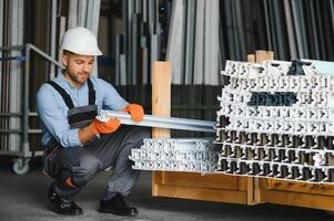 Factory for aluminum and PVC windows and doors production. Manual worker assembling PVC windows and doors. photo