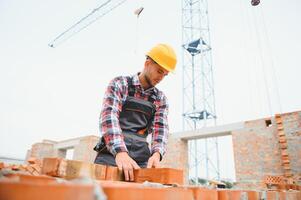 trabajador de la construcción en uniforme y equipo de seguridad tiene trabajo en la construcción foto