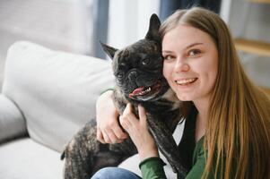 Female owner playing with joyful dog at home. Playing with dog concept photo