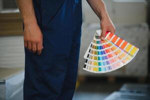 Funny portrait of typographer standing with color swatches at the printing manufacturing photo