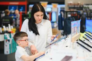 woman with son in store buying new phone. photo