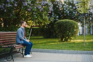 ciego hombre. personas con discapacidad, minusválido persona y todos los días vida. visualmente dañado hombre con caminando palo. foto