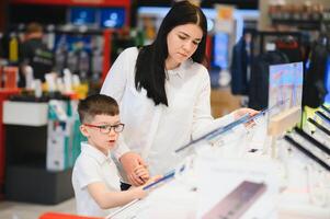 woman with son in store buying new phone. photo