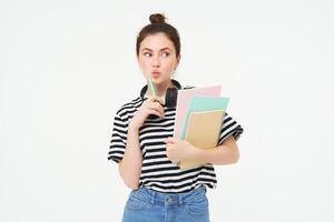 imagen de joven mujer, tutor con libros y cuadernos, vistiendo auriculares terminado su cuello, aislado en blanco antecedentes. estudiante estilo de vida concepto foto