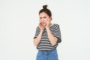 Image of woman looking scared, apalled by something shocking, standing over white background photo