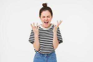 Portrait of angry woman shouting and shaking hands, losing her temper, arguing, standing over white background photo