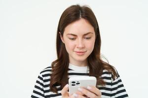 retrato de mujer comprobación su mensajes en móvil teléfono, mirando a teléfono inteligente pantalla foto