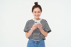 tecnología y estilo de vida. joven mujer en pie terminado blanco antecedentes con teléfono inteligente foto