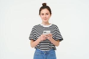 tecnología y estilo de vida. joven mujer en pie terminado blanco antecedentes con teléfono inteligente foto