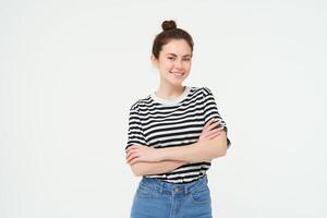 Image of charismatic young woman in striped t-shirt and jeans, looking confident and happy, smiling at camera, candid emotions, white background photo