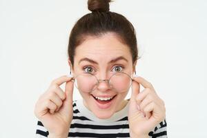 Close up portrait of woman with happy face, leaning towards camera as if reading amazing text, great news, wearing glasses, isolated over white background photo