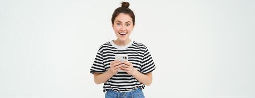 Technology and people concept. Young woman with mobile phone, smiling, using smartphone app, social media application, isolated over white background photo