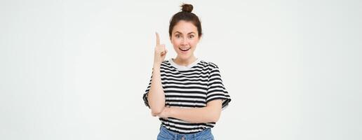 retrato de creativo joven mujer, muestra eureka gesto, pone en uno dedo, puntos arriba, sugiere un plan, tiene un idea, soportes terminado blanco antecedentes foto