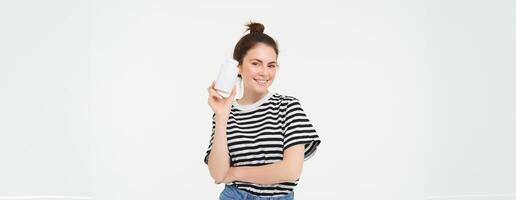 Healthcare and wellbeing. Young woman holding bottle with vitamins, dietary supplements, treatment for good skin and hair, standing over white background photo