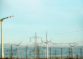 Wind farm park and high voltage towers next to a road in Austria in sunny weather. photo